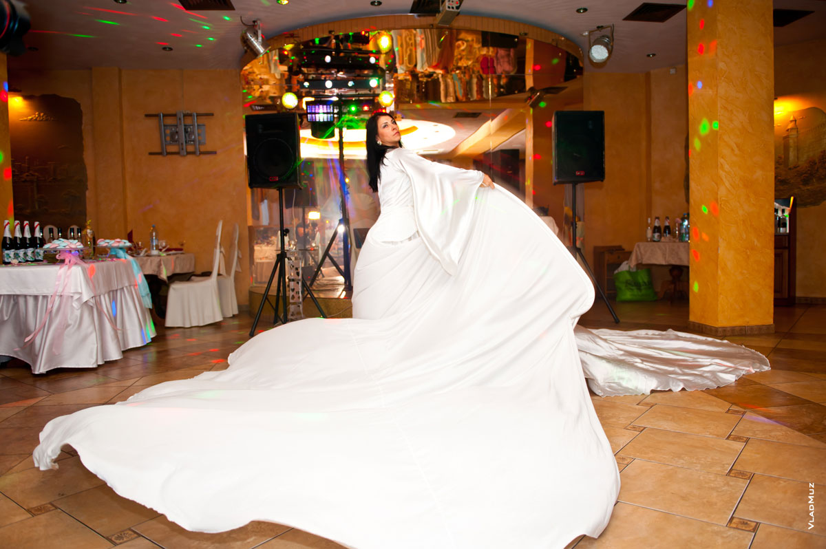 Фото девушки на танцполе в ресторане в развевающемся белом платье