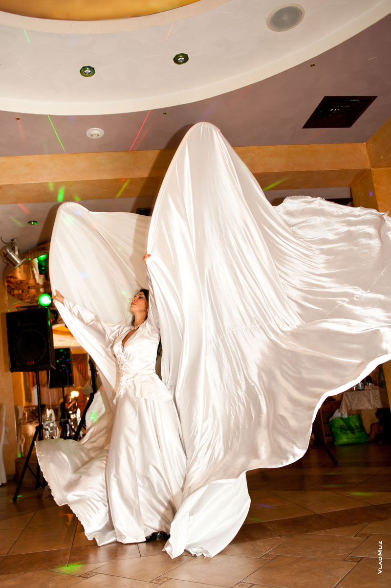 Фото танца девушки в большом белом платье с огромным шлейфом