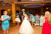 Девушки с лентами в руках ведут хоровод вокруг невесты с букетом