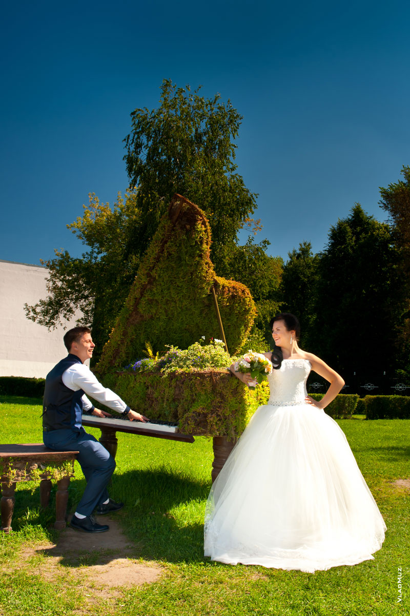Фото смеющихся жениха с веселой у декоративного рояля на лужайке ДК Калинина в Королеве
