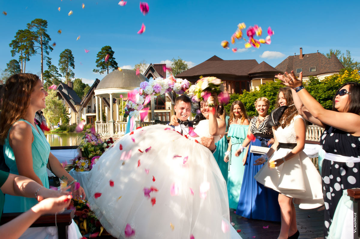 Фото свадебной пары под салютом из лепестков роз и овации