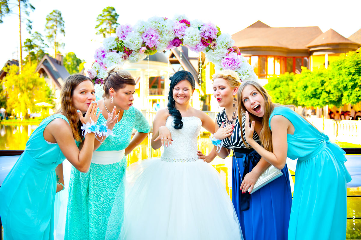 Фото улыбающейся невесты, показывающей обручальное кольцо, восторженных подруг невесты