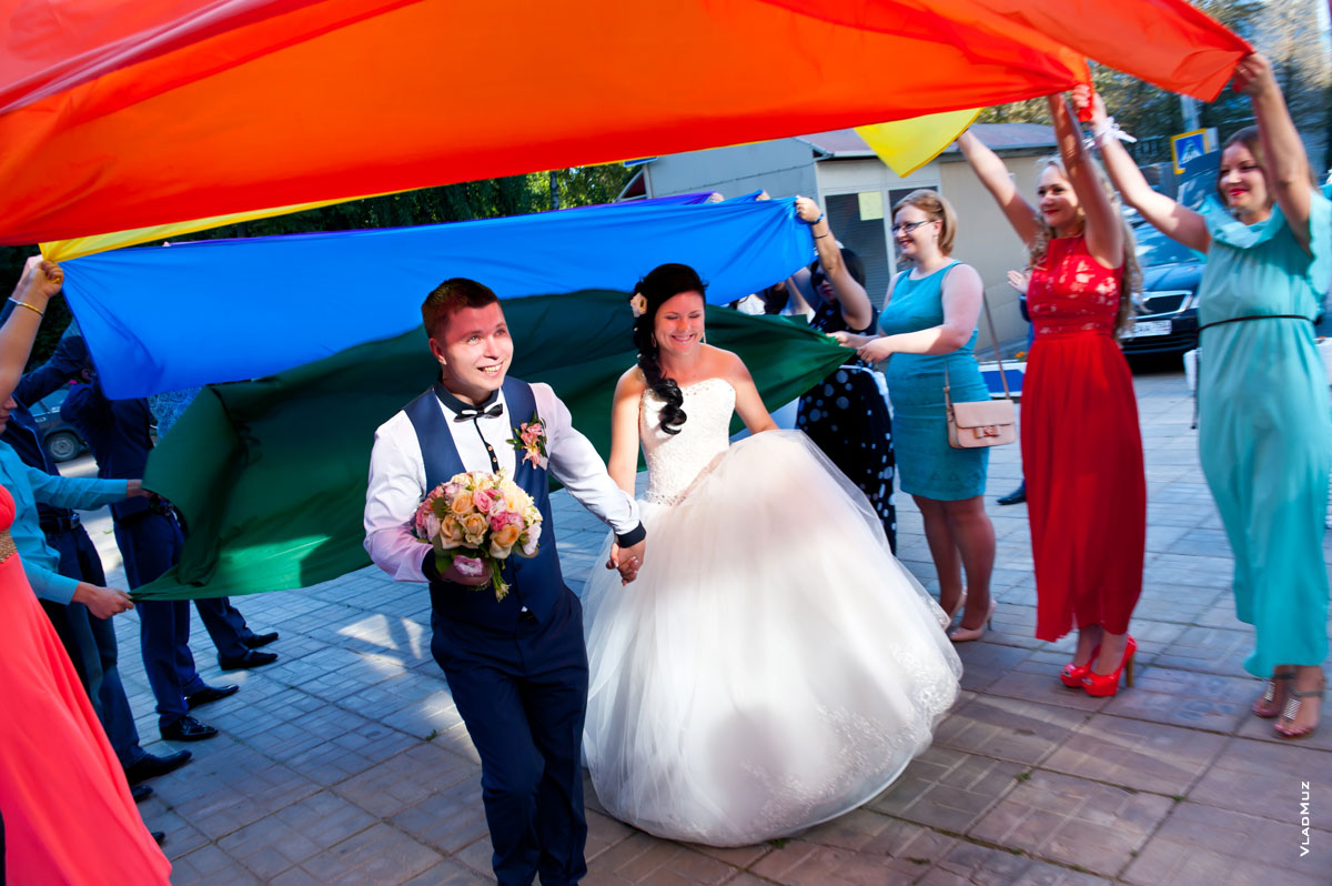 Фото свадебной пары, цветных тканей над молодоженами и девушек в ярких платьях