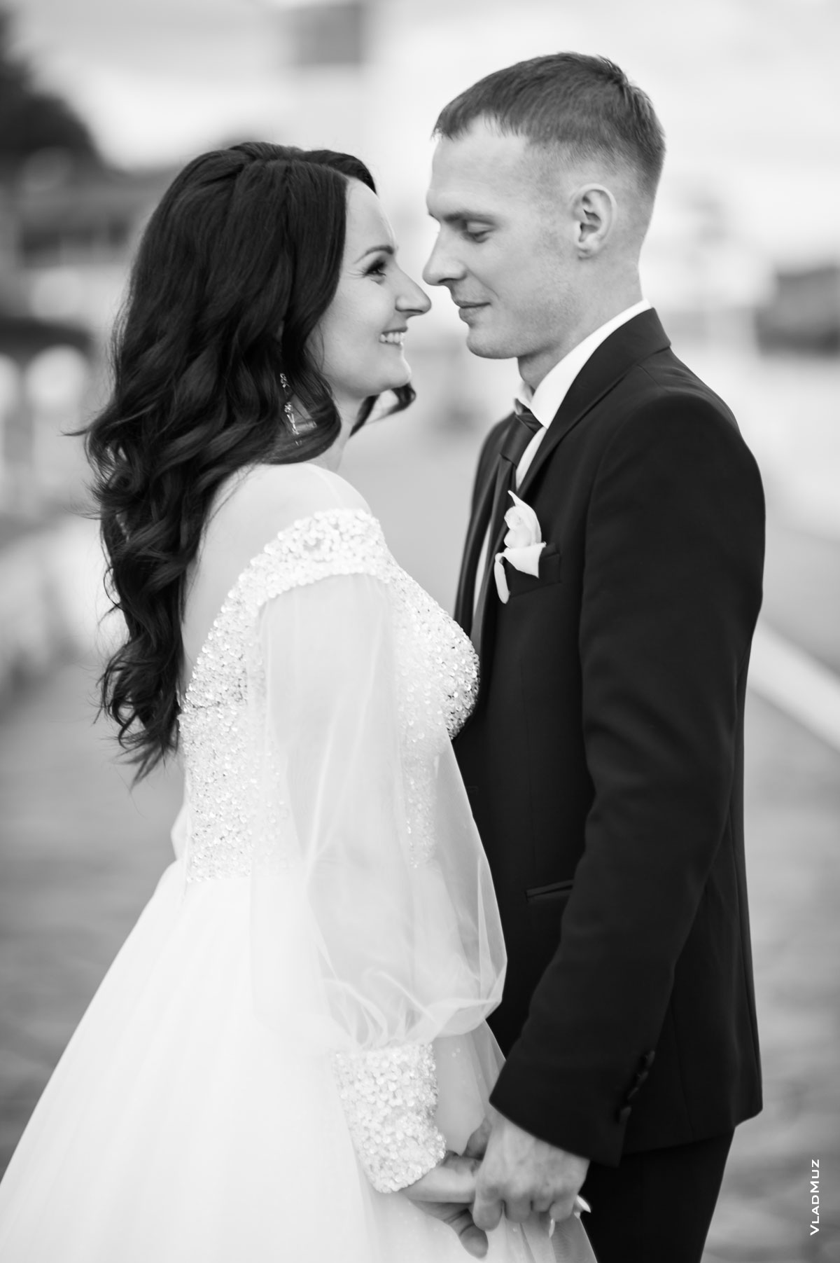 Ч/б поясное фото жениха с невестой в профиль, напротив друг друга, держащихся за руки