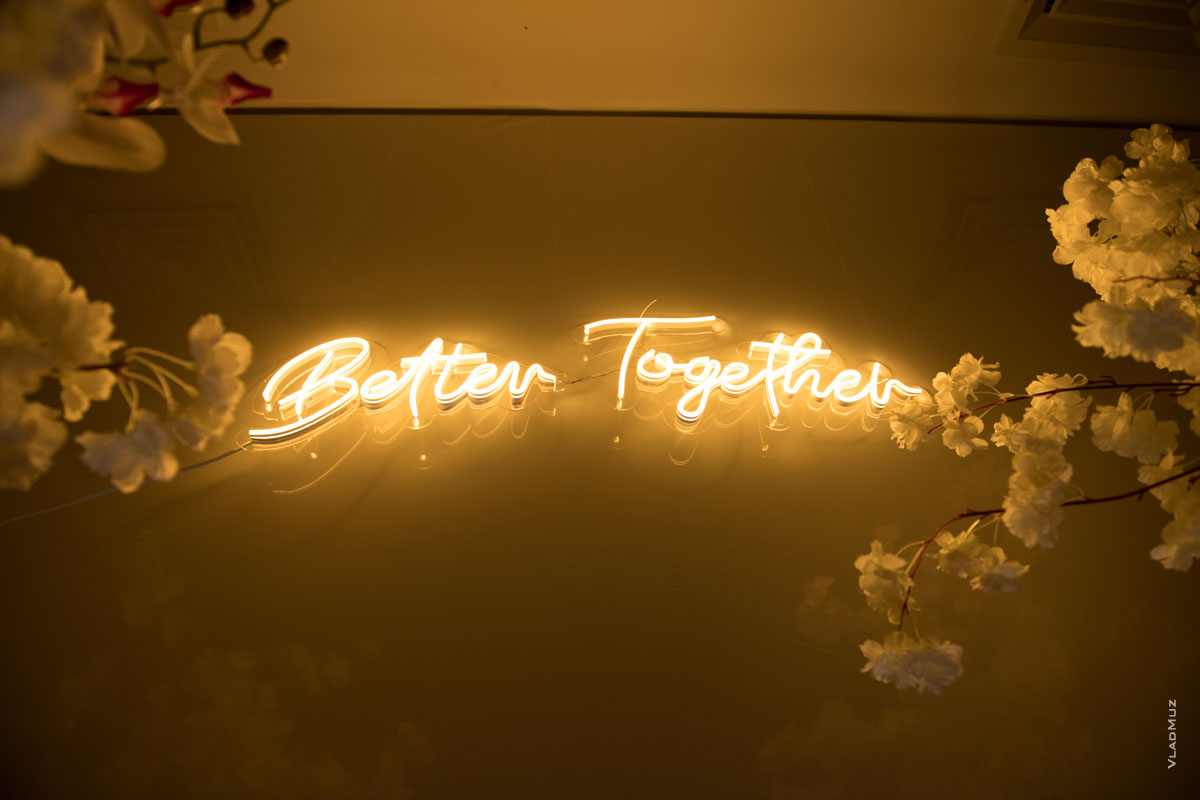 Фото неоновой надписи “Better Together” («лучше вместе») над женихом и невестой