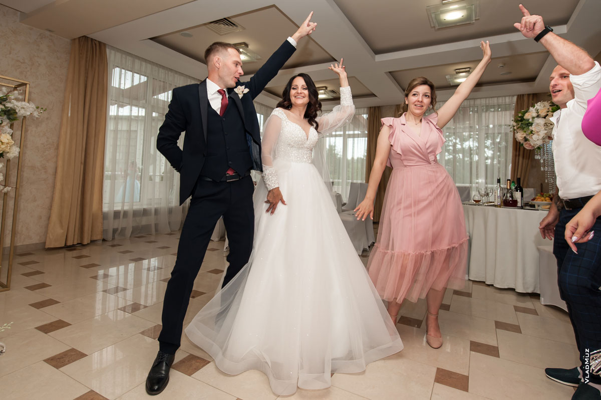 Фото свадебной дискотеки в ресторане: танцующие гости и жених с невестой