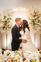 Фото поцелуя молодоженов за свадебным столом в ресторане «Белый берег»