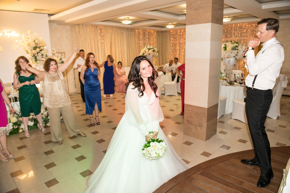 Фото свадебного ведущего, невесты с букетом перед его броском и подруг на заднем плане