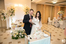 Фото жениха и невесты, разрезающих свадебный торт