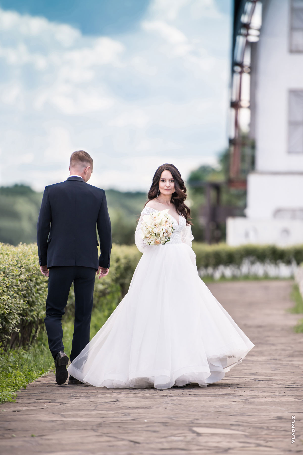 Свадебный штамп во время свадебной прогулки: молодожены идут впереди, невеста оборачивается назад