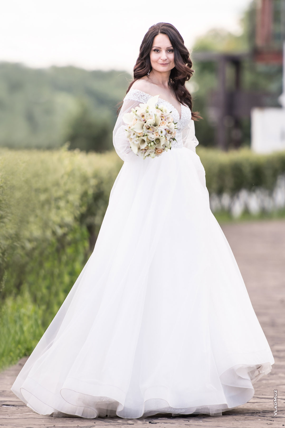 Фотопортрет невесты с букетом в полный рост во время свадебной прогулки по территории ресторанно-гостиничного комплекса «Белый берег» в Московской области