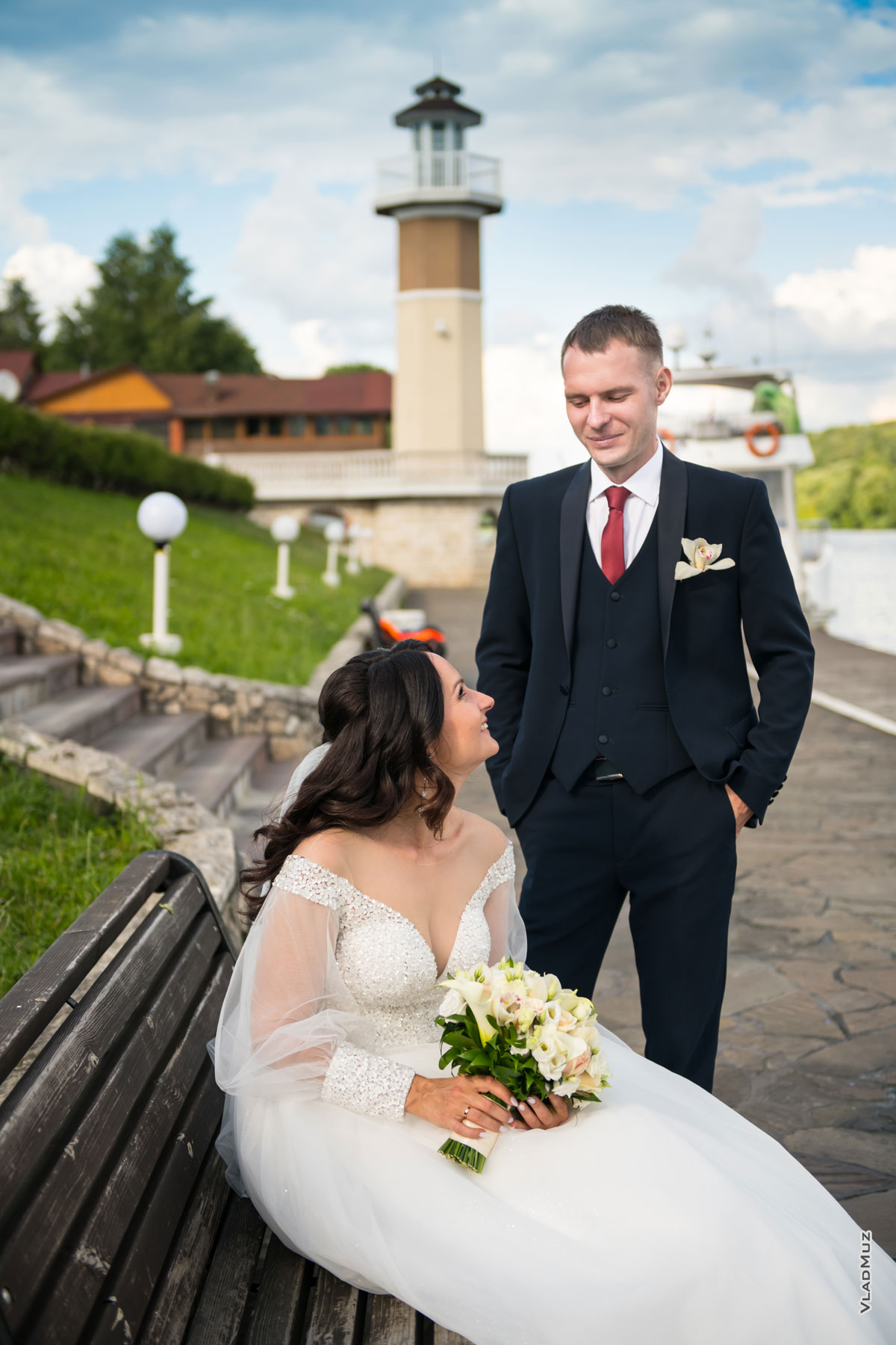 Фото невесты и жениха, смотрящих друг на друга, на фоне маяка ресторана «Белый берег» (Раменский район, с. Верхнее Мячково)