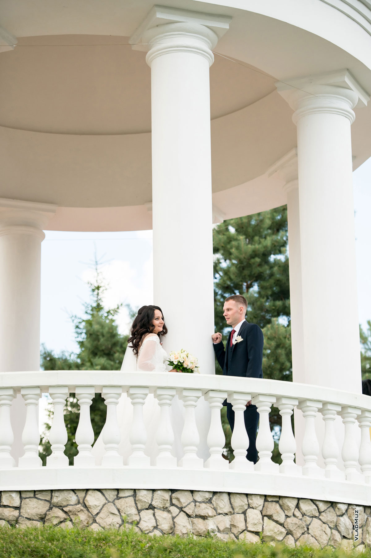 Свадебный фотосет в ротонде: жених и невеста смотрят друг на друга