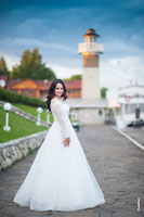 Фото невесты в полный рост, на набережной комплекса «Белый берег», на фоне маяка