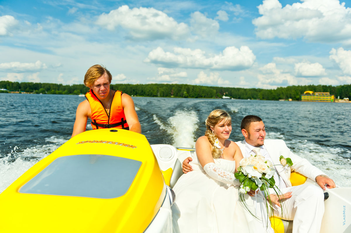Фото жениха с невестой и водителя свадебного катера во время прогулки в Бухте радости Пироговского водохранилища