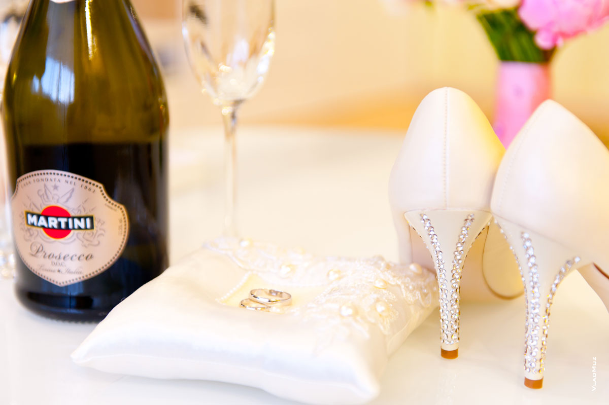 Фото бутылки Martini, свадебных колец и свадебных туфель невесты