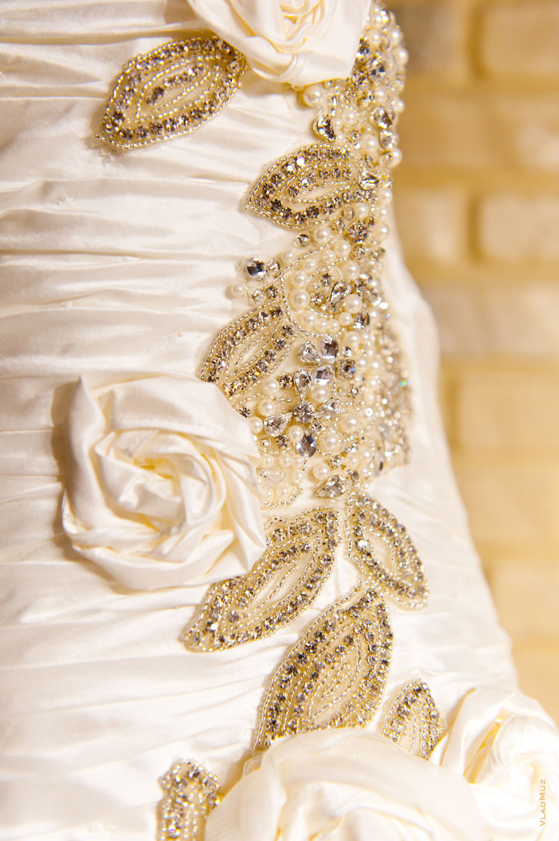 Фото кружевных цветов из материи и бисера на свадебном платье