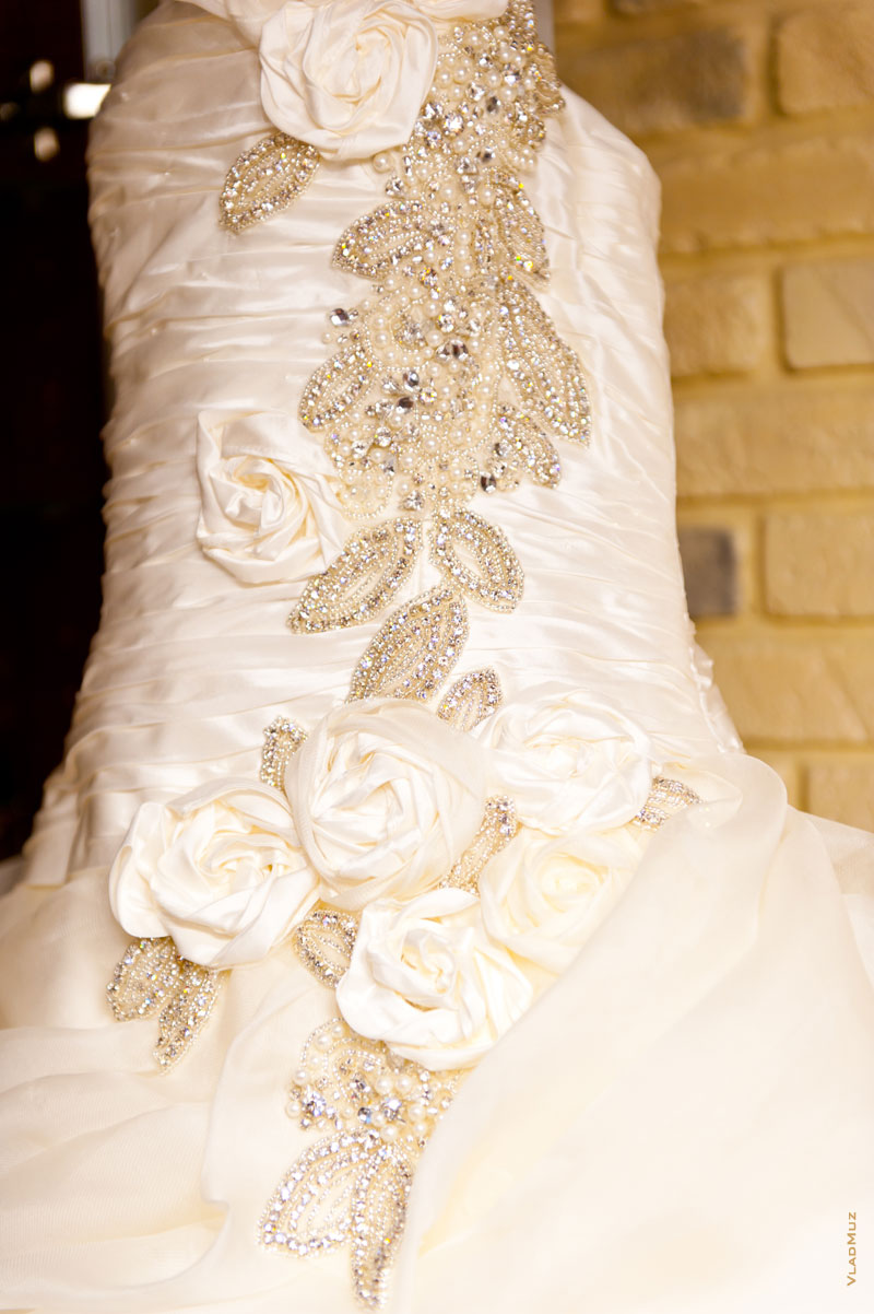 Фото украшений на дизайнерском свадебном платье крупным планом