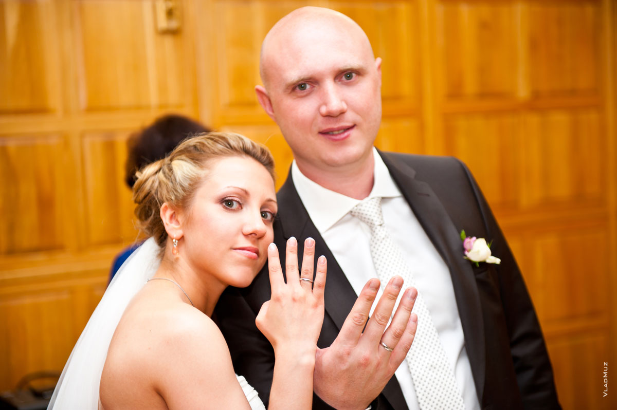 Фото жениха и невесты, показывающих обручальные кольца на руках