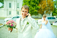 Фото жениха с букетом в фокусе и невестой в расфокусе