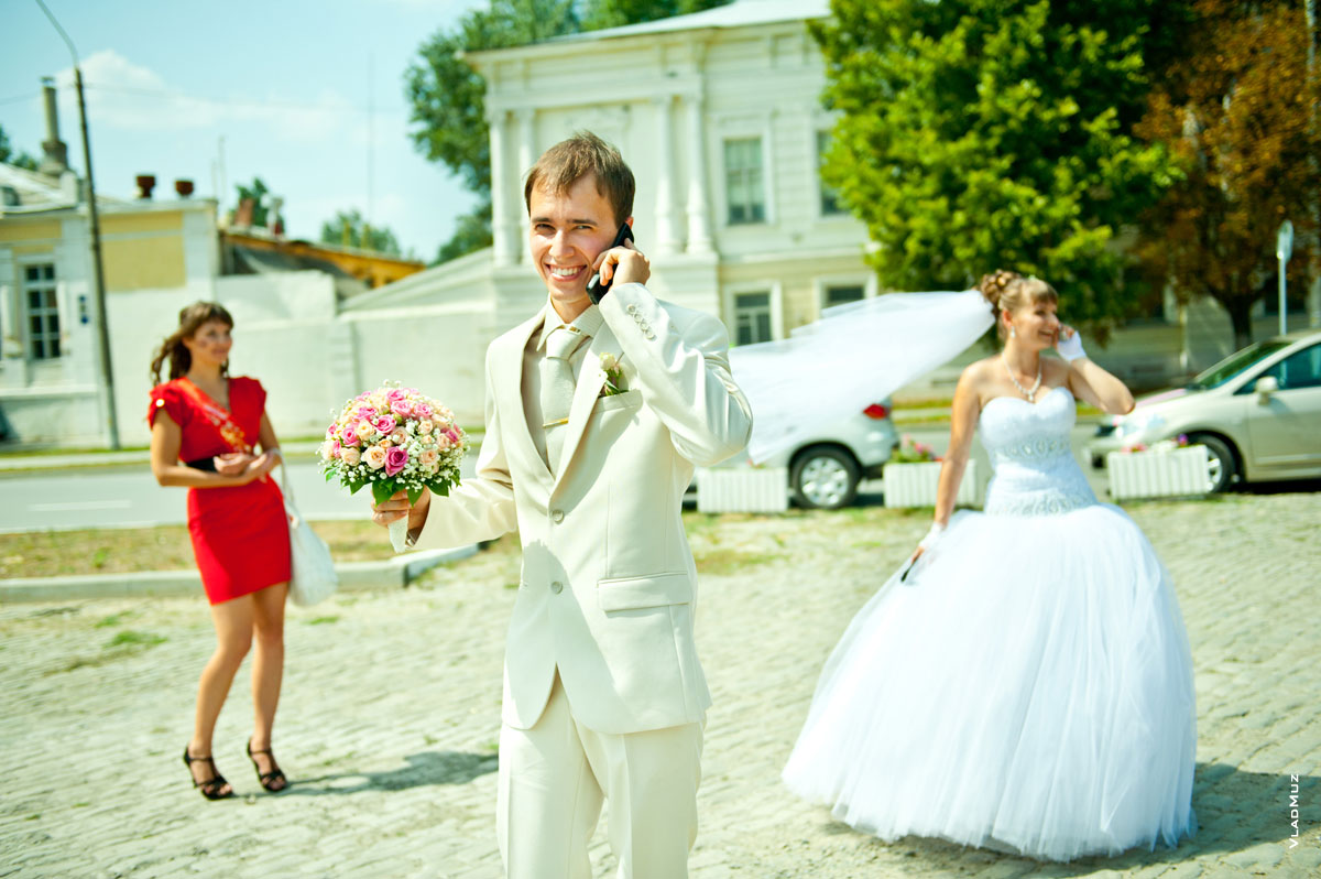 Фото жениха, невесты, принимающих поздравления по телефонам, и девушки в красном