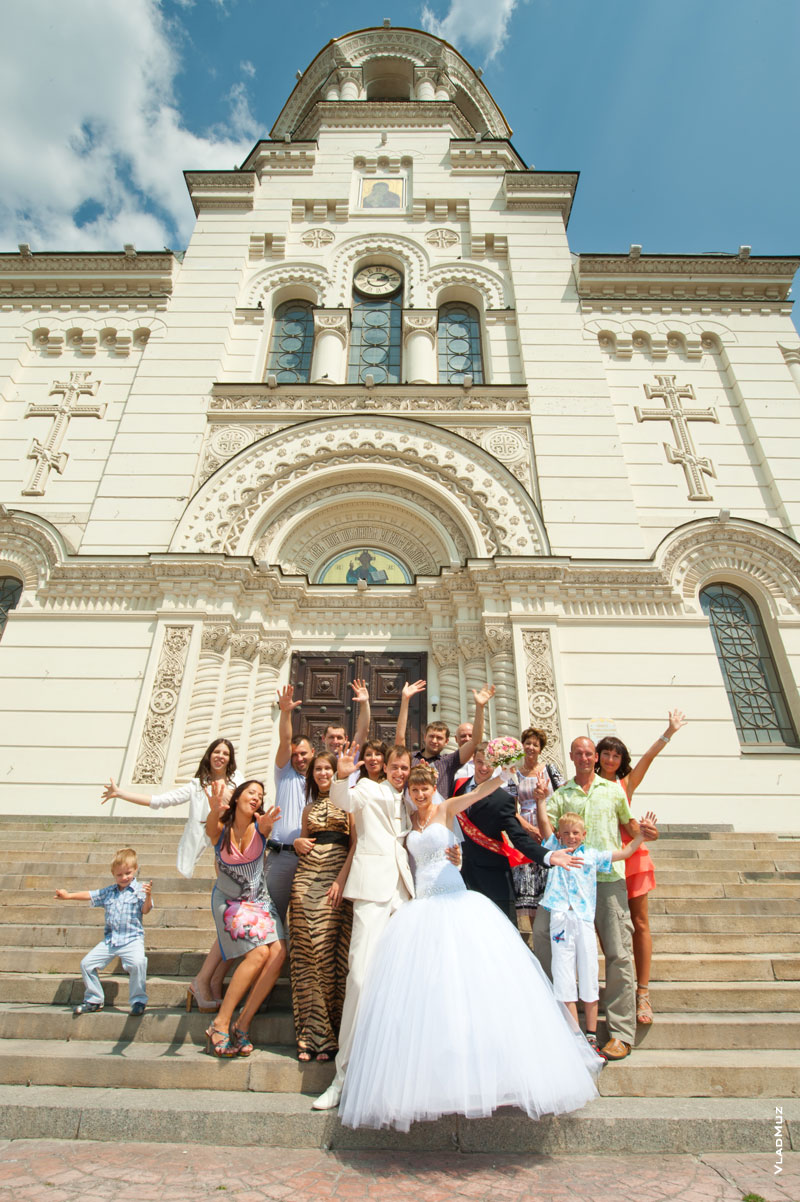 Живое свадебное групповое фото на ступенях на фоне Вознесенского собора в Новочеркасске