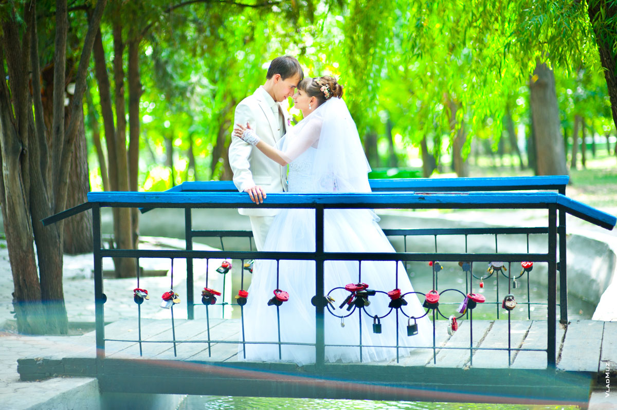 Фото свадебной пары на мостике со свадебными замками в Александровском парке в Новочеркасске