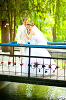 Свадебное фото жениха с невестой на мосту в полный рост с улыбкой