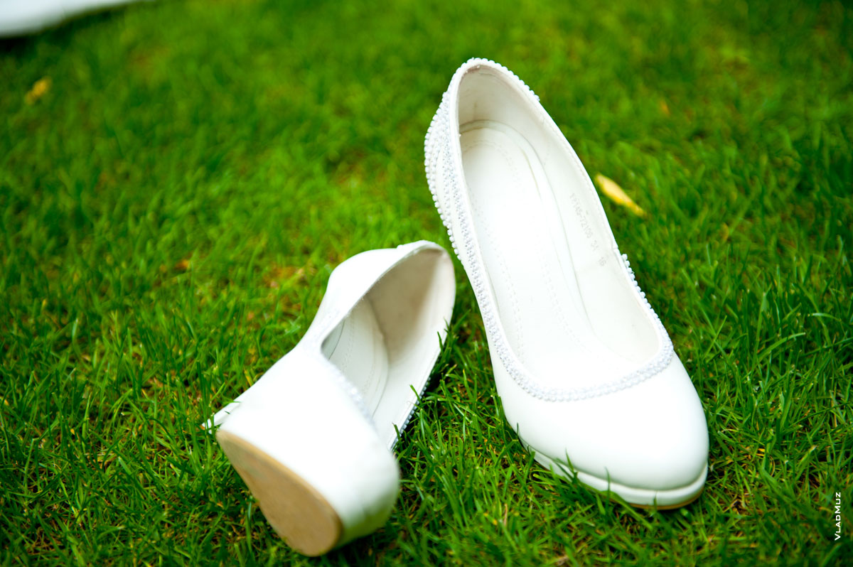 Фото белых свадебных туфель невесты на зеленой траве