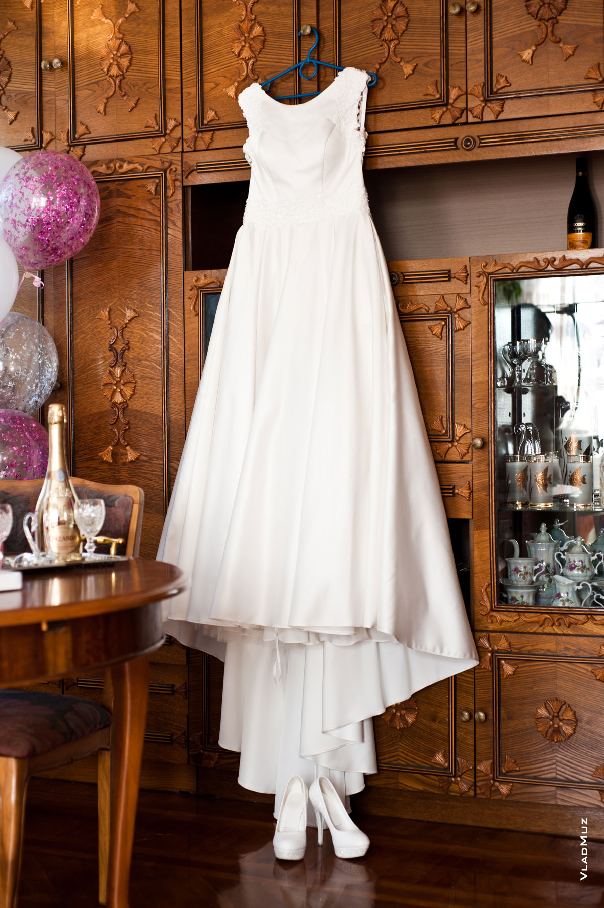 Фото свадебного платья на вешалке и туфель невесты