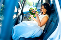 Фото невесты с букетом на заднем сидении свадебного автомобиля