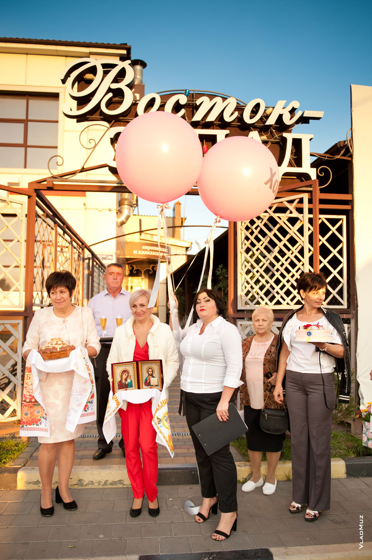 Фото родителей и ведущей перед входом в кафе «Восток-Запад» в Новочеркасске