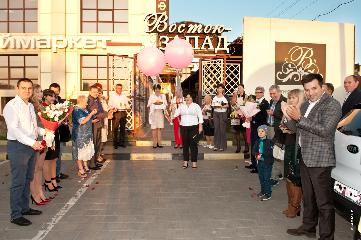 Фото гостей и ведущей, встречающих свадебную пару перед входом в кафе «Восток-Запад» в Новочеркасске