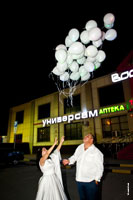 Фото жениха и невесты, отпустивших в ночное небо свадебные воздушные шары в конце свадьбы