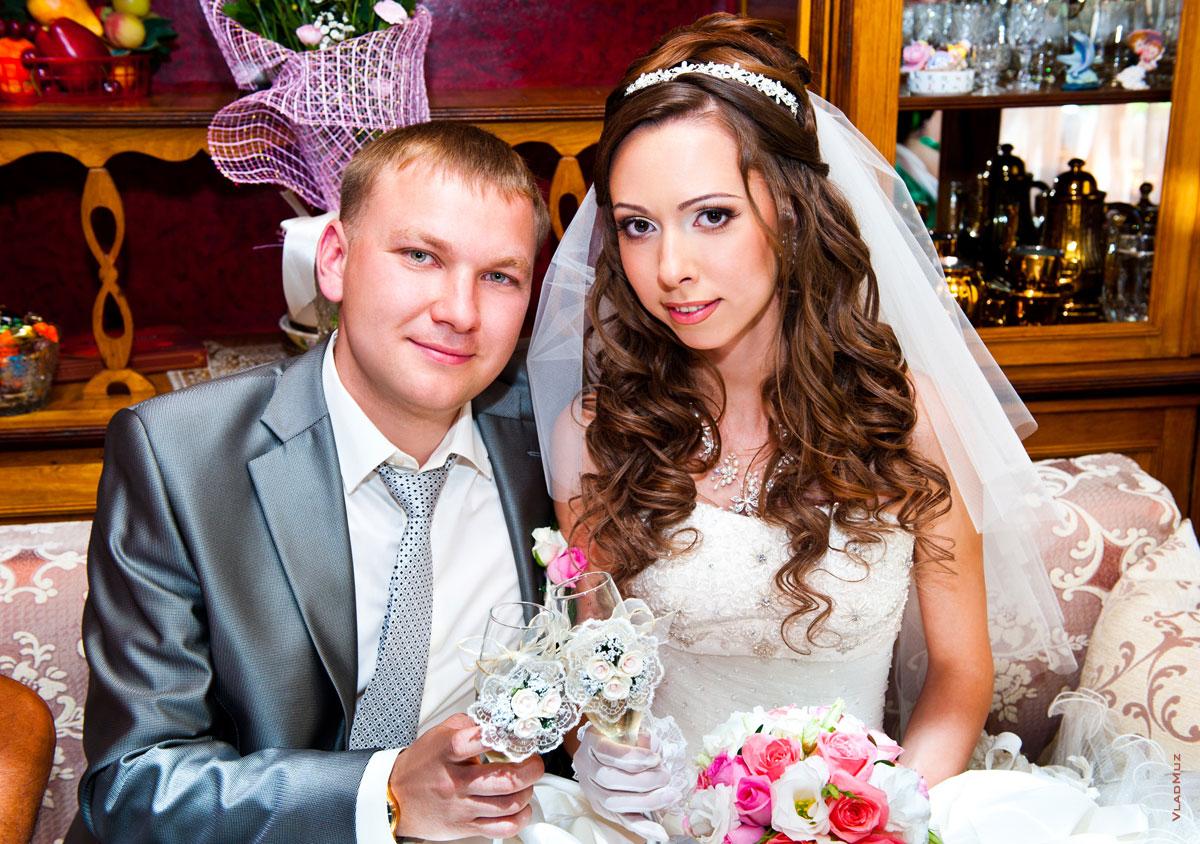 Парный свадебный фотопортрет жениха и невесты с бокалами после выкупа невесты