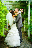 Поцелуй жениха и невесты в аллее ботанического сада Толоконникова