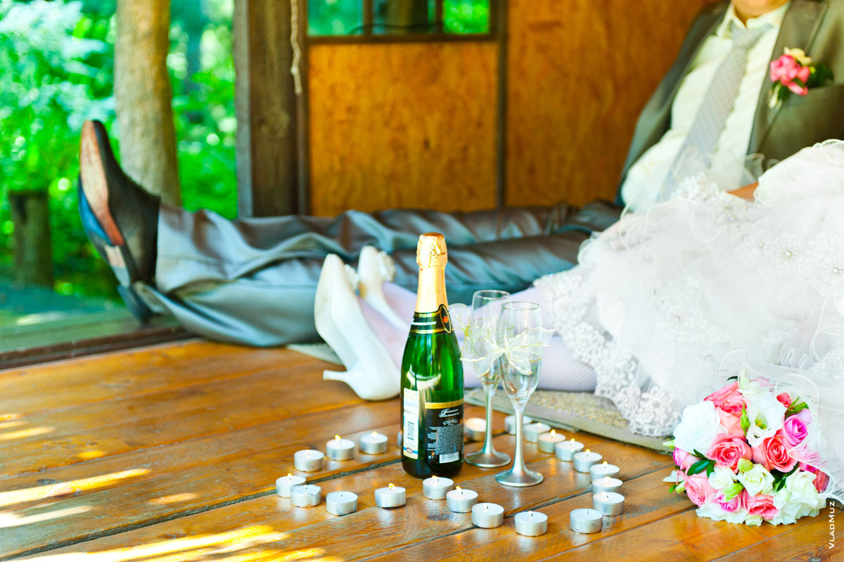 Свадебная фотография молодоженов с шампанским, бокалами, свечами и цветами