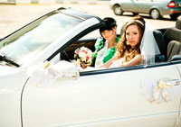 Фото невесты за рулем свадебного кабриолета с подружкой