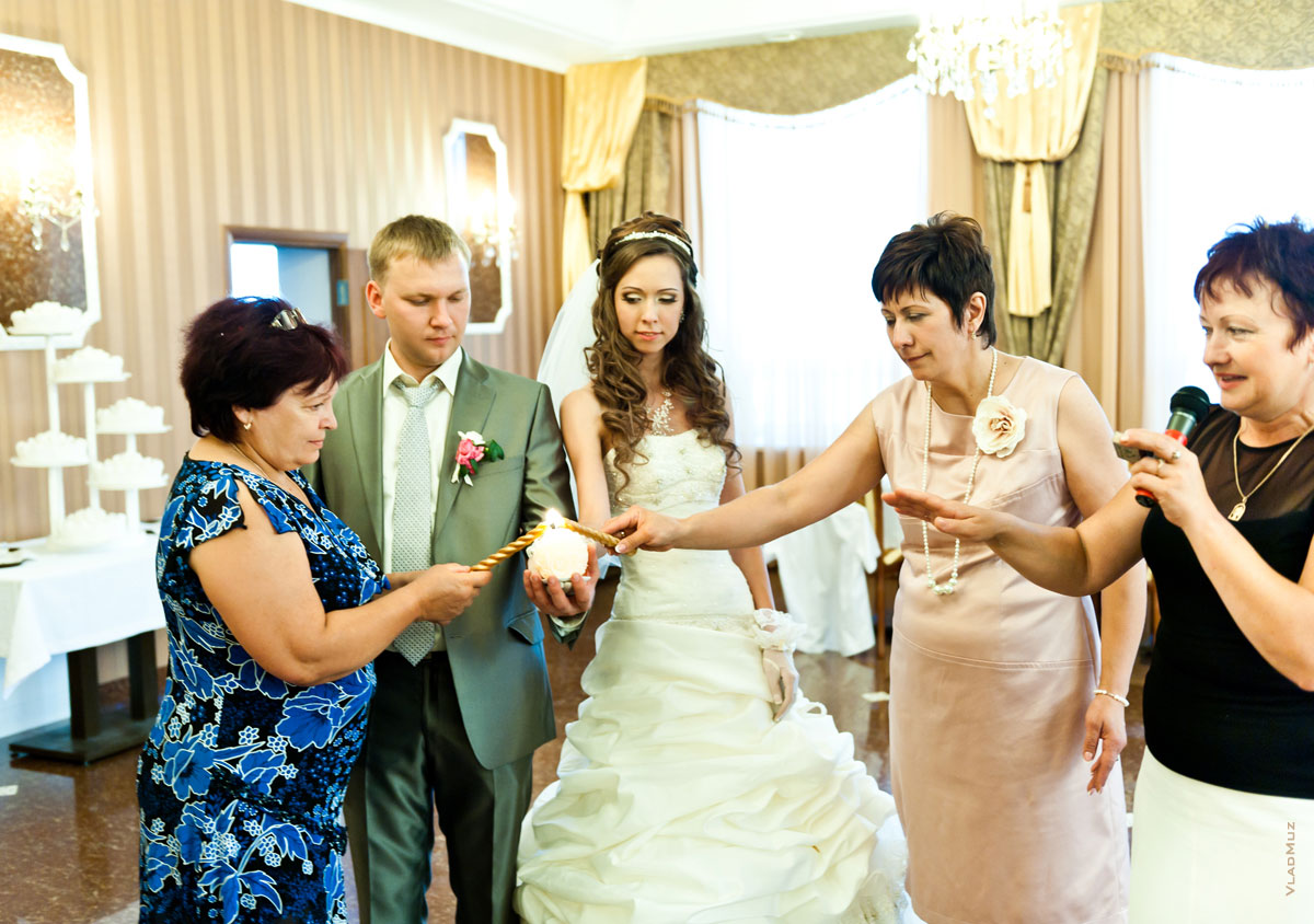 Фото родителей и жениха с невестой, зажигающих семейный очаг