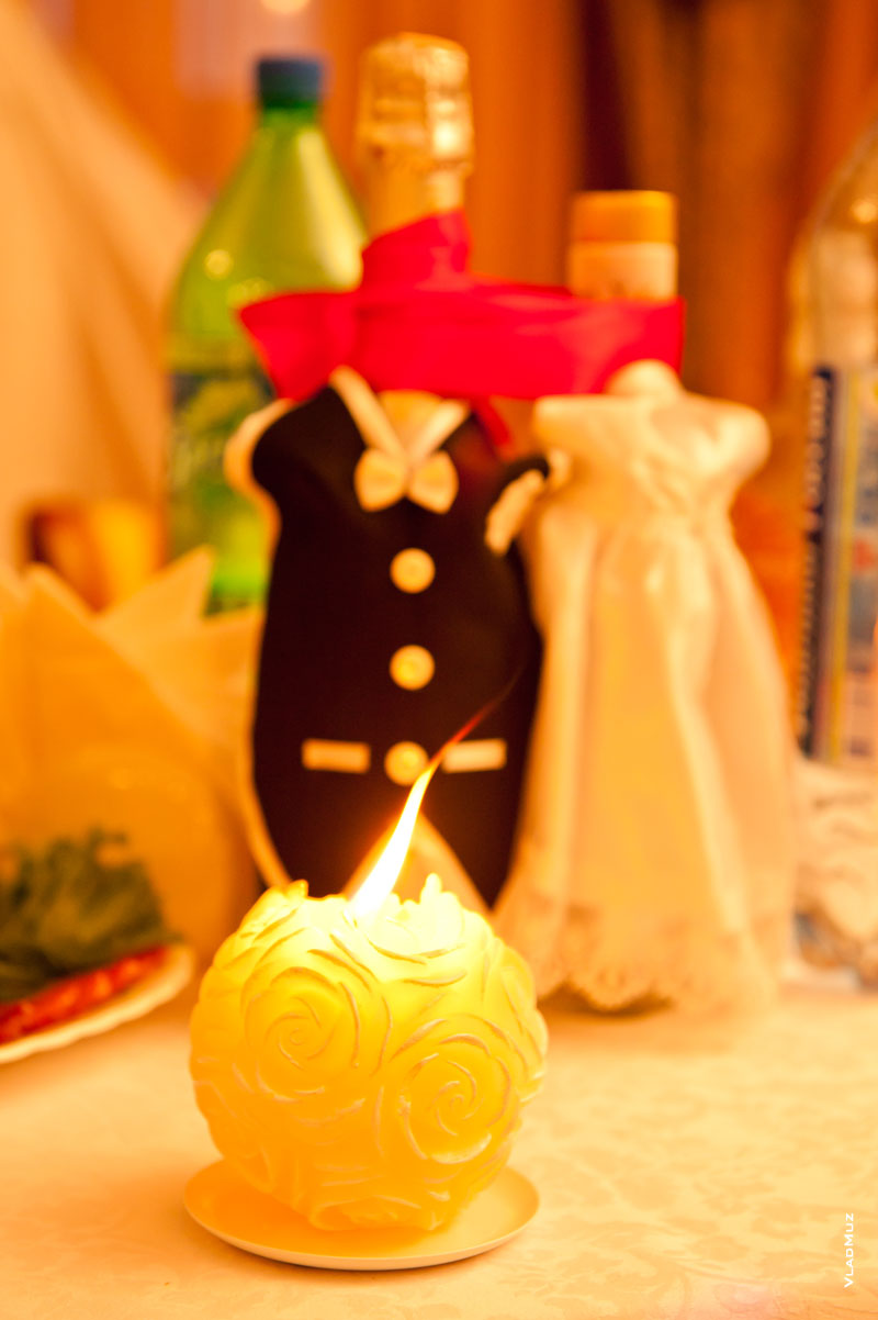 Красивый фото натюрморт: горящая свеча и свадебные «быки»