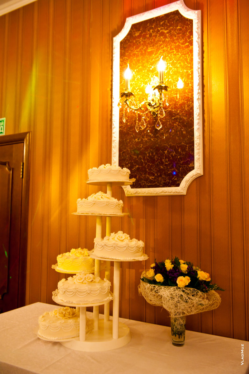 Красивая фотокомпозиция со свадебным тортом, свечами и цветами