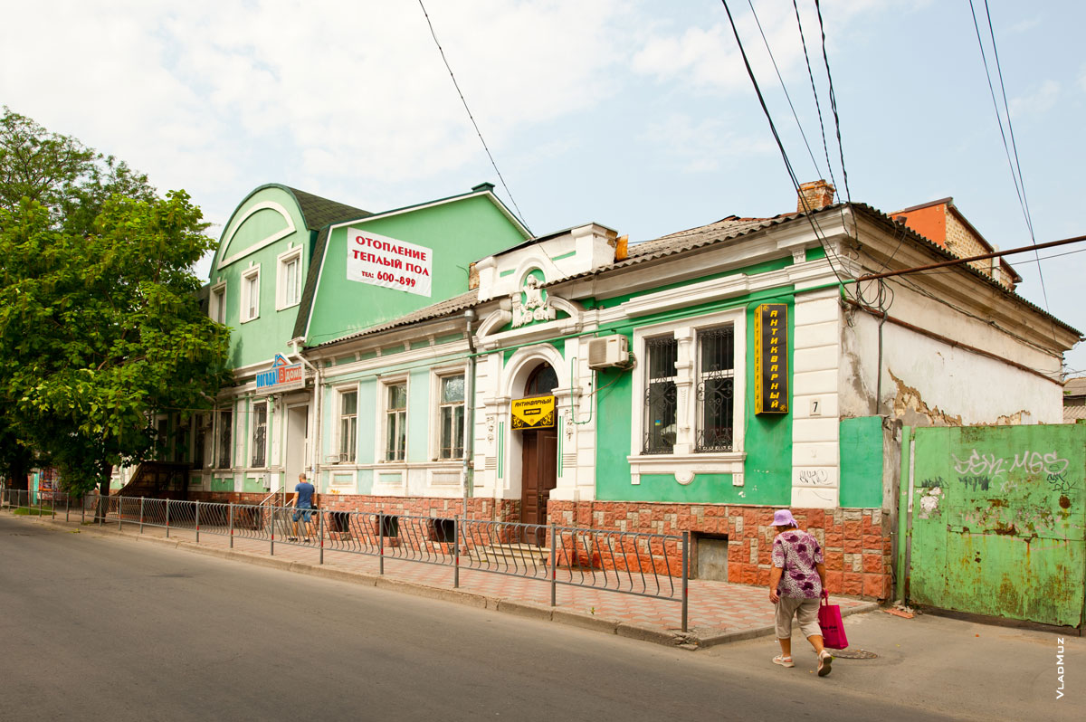 Старинный 1-этажный дом зеленого цвета с барельефом на фронтоне на улице Толстого в Симферополе