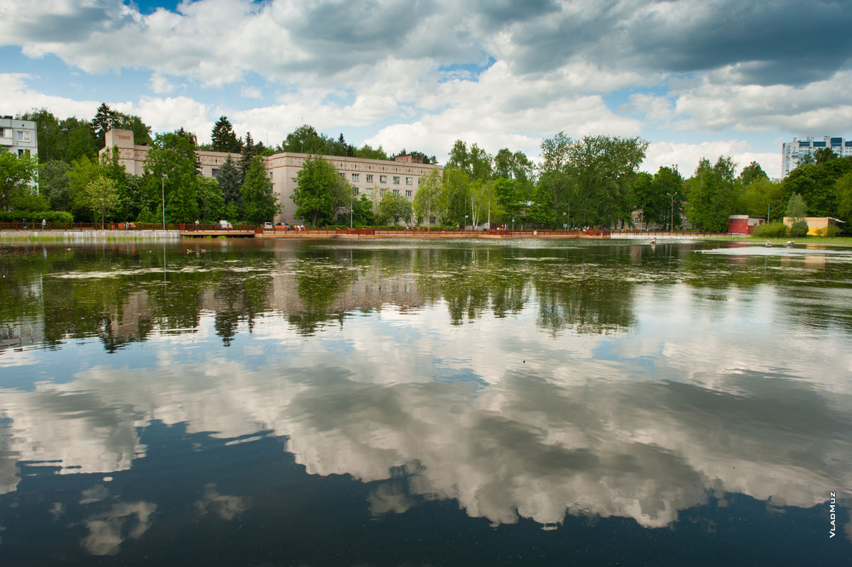 Фото озера и здания гостиницы в мкрн. Юбилейном г. Королёва Московской области на фоне неба и его отражения в воде