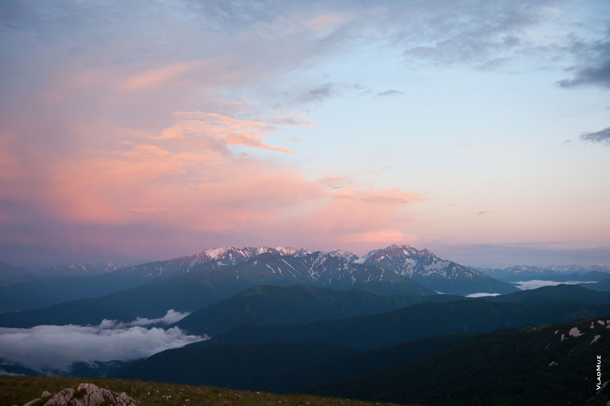 Фото высоких гор Кавказа вдали в красных лучах закатного солнца