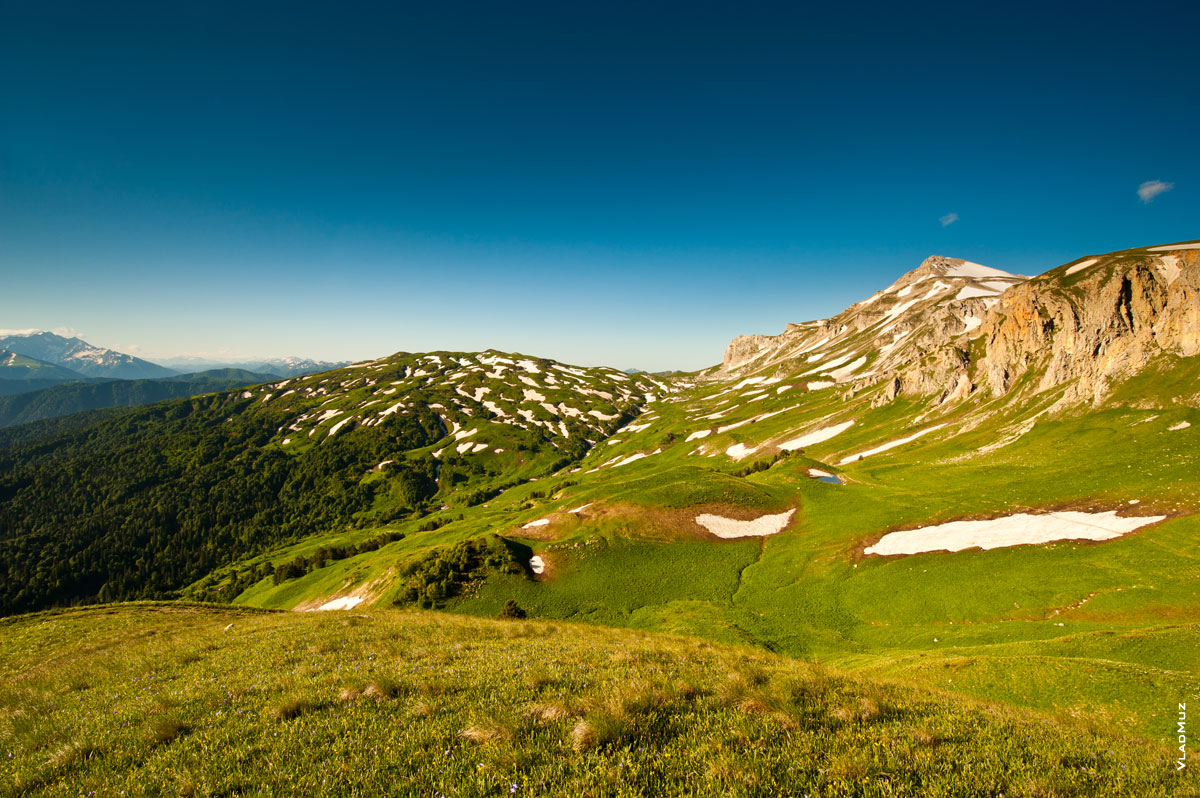 Фото пятнистой бело-зеленой горы Гузерипль, справа высится гора Оштен