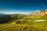 Пятнистая бело-зеленая гора Гузерипль, справа высится гора Оштен