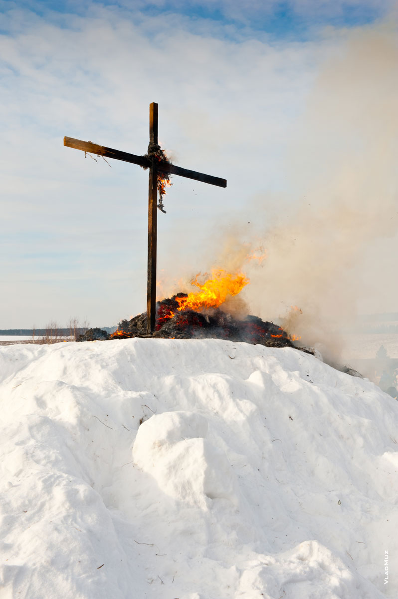 Фото черного креста в «Лудорвае» и догорающих частей чучела Масленицы на снежном холме