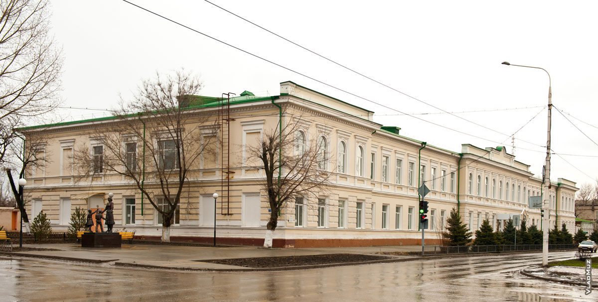 Фото белого старинного 2-этажного здания на пересечении пр. Ермака и ул. Просвещения в Новочеркасске