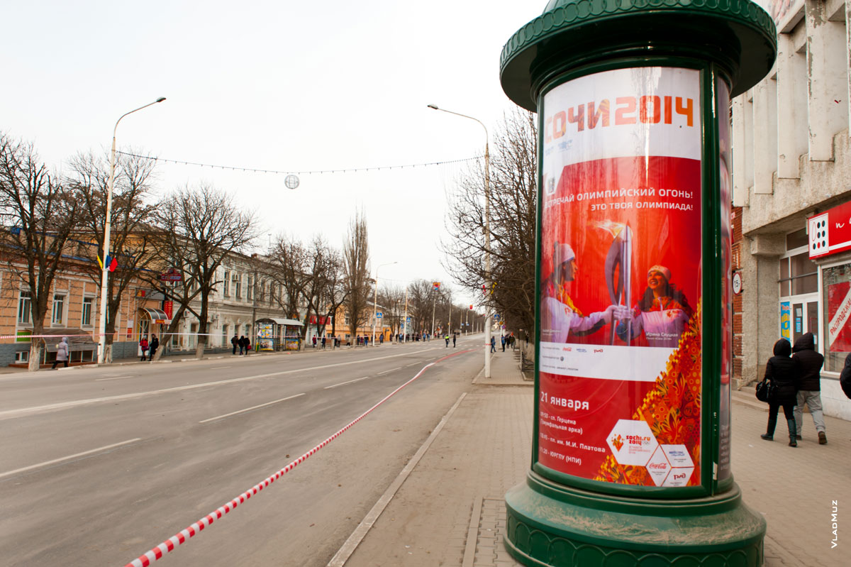 Фото тумбы с рекламой эстафеты Олимпийского огня на улице Московской в Новочеркасске