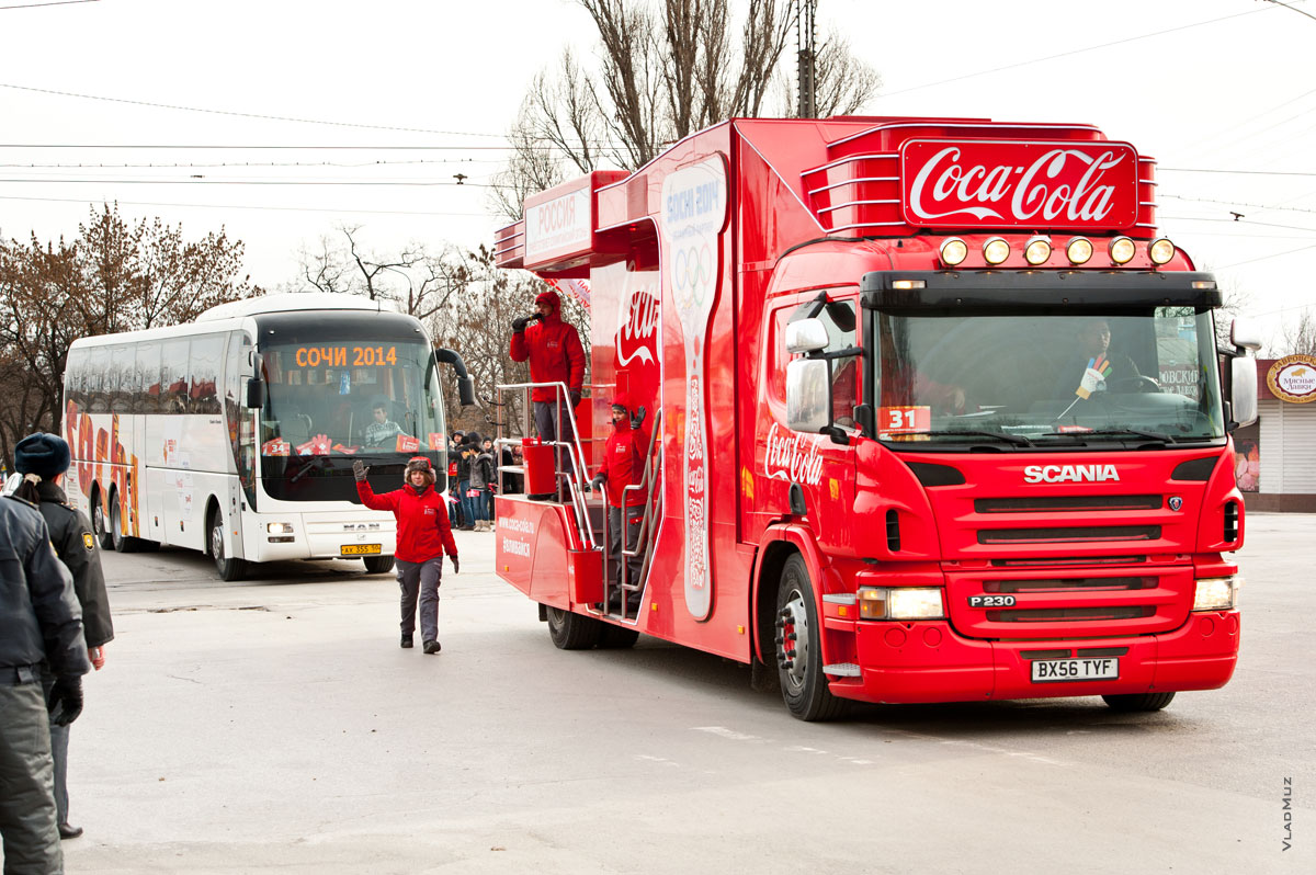 Фото колоны сопровождения Олимпийского огня с красной машиной «Кока-Колы» в начале